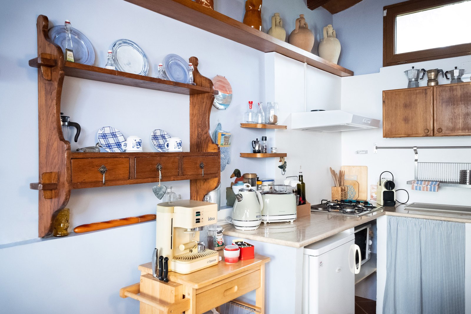 graziosa cucina con macchina del caffe, tostapane, bollitore, fornelli, frigo e vari accessori